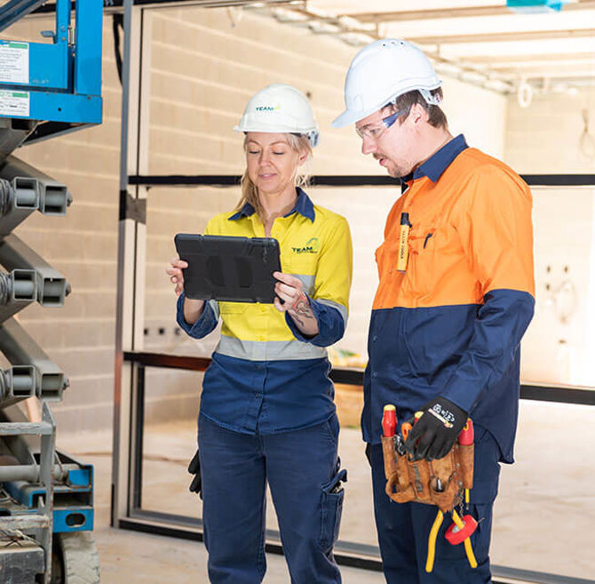 Electricians Looking At The Ecawa Technical Knowledge Base On An Ipad